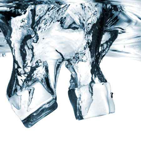 ice cubes dropped into water with splash isolated on whiteの写真素材