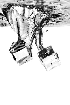 ice cubes dropped into water with splash isolated on whiteの写真素材