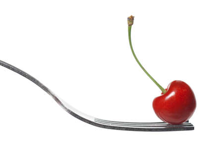 red cherry on fork isolated on whiteの写真素材