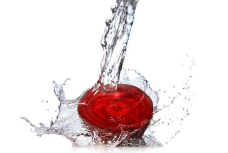 red beet with water splash isolated on whiteの写真素材