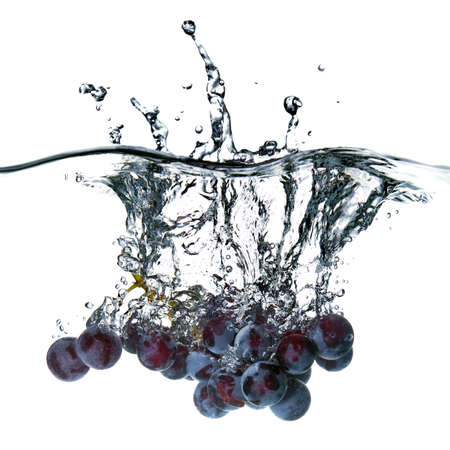 blue grape dropped into water with splash isolated on whiteの写真素材