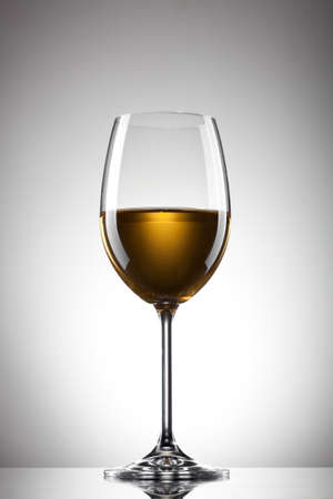 White wine in the glass on whiteの写真素材
