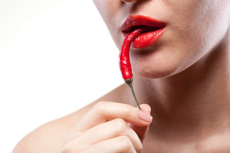 Young woman with chili pepper isolated on whiteの写真素材