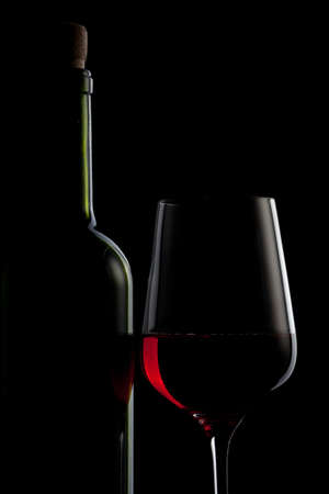 red wine in glass and bottle isolated on blackの写真素材