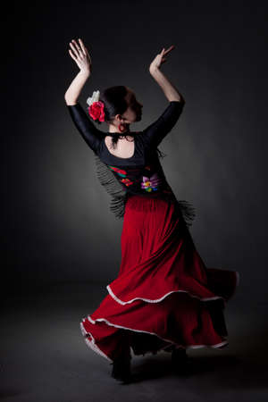 young woman dancing flamenco on blackの写真素材
