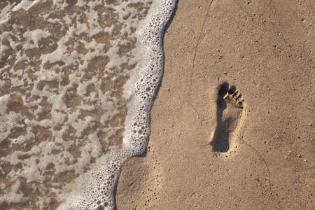 sand with footprint and water wave
