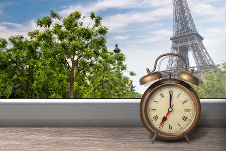 View of Paris and Eiffel tower from window with alarm clock