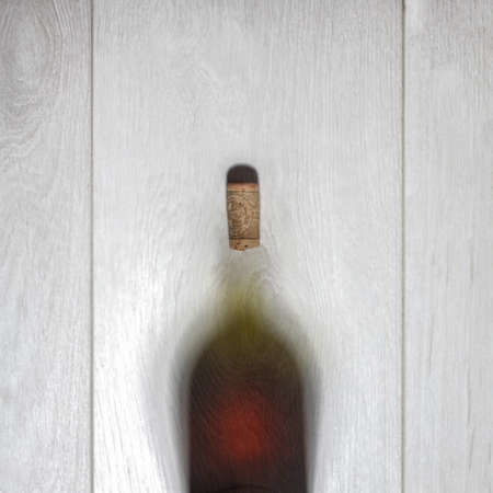 Bottle of red wine with cork on white wooden table. Top viewの写真素材
