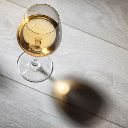 Glass of white wine on wooden table. Top viewの写真素材