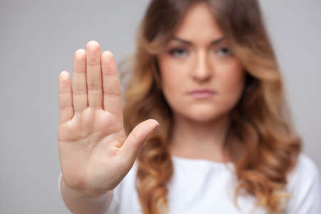 female hand stop sign on grey background