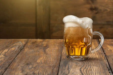 Light beer in mug on wooden backgroundの写真素材