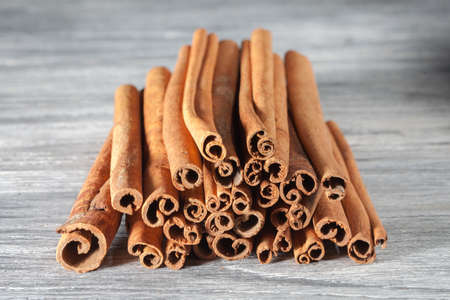 Cinnamon sticks isolated on white wooden table