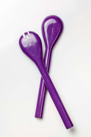 purple cooking spoons isolated on whiteの写真素材