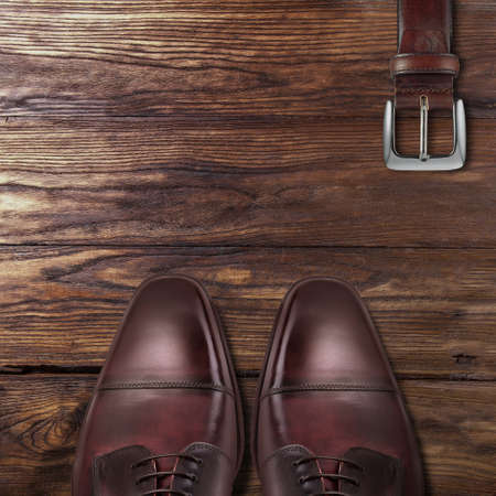 Classic male brown leather shoes with belt on woodの写真素材