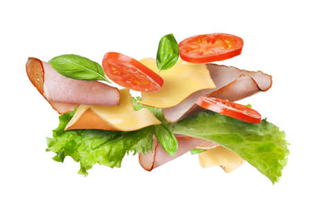 Ingredients for sandwich falling in the air isolated on white - slices of fresh tomatoes, ham, cheese and lettuceの写真素材