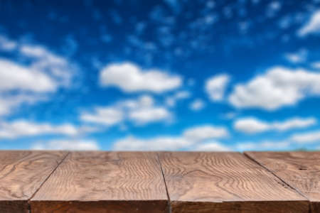 Empty wooden table with sky on background