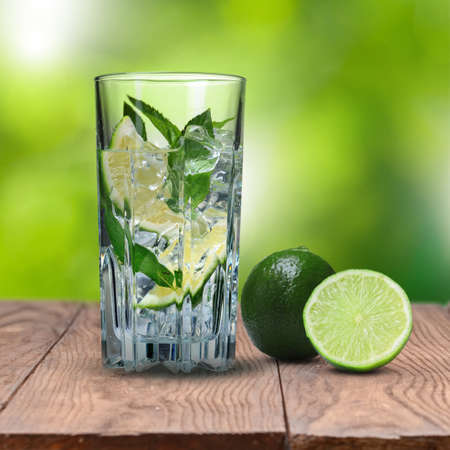mohito cocktail with lime on wooden table against green natural backgroundの写真素材