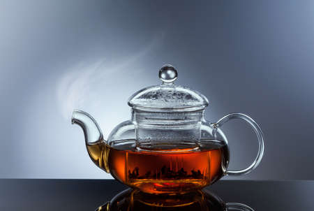glass teapot cup with hot black tea and steamの写真素材
