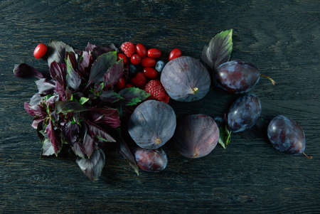 basil, rries and ripe on the black wood background , view from aboveの写真素材