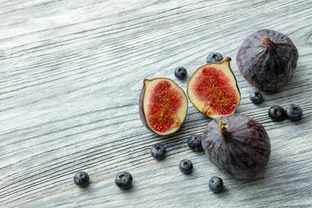 Fresh figs and blueberries, on white wood background