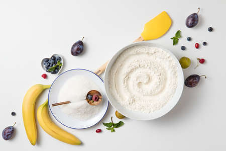 ingredients for the banana cake with berries on white backgroundの写真素材