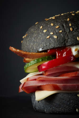 Gourmet black burger with Spicy sauce on black backgroundの写真素材