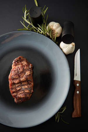 Juicy steak medium rare beef with spices on dark tableの写真素材