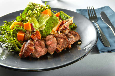 delicious, grilled meat duck with roasted pumpkin and fresh green herb salad on a plateの写真素材