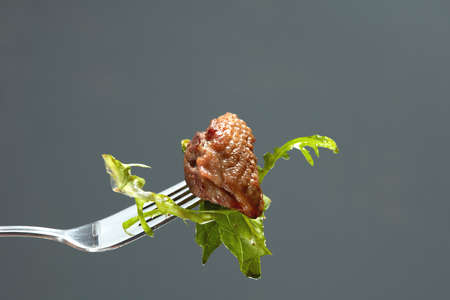 duck meat and salad on a fork Isolated on blackの写真素材
