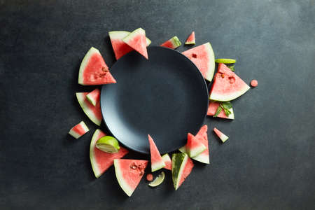 slices of watermelon placed in a circle of black plate. Space for textの写真素材