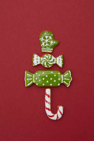 Christmas tree from different gingerbread cookies on a red background. Christmas card