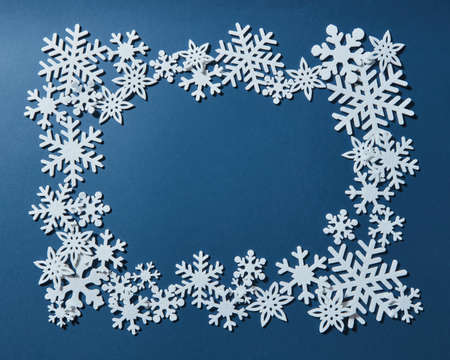 Christmas decorative frame of snowflakes. On a blue background.の写真素材
