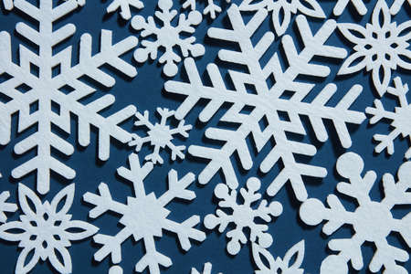 Beautiful winter background with white snowflakes on a blue backgroundの写真素材