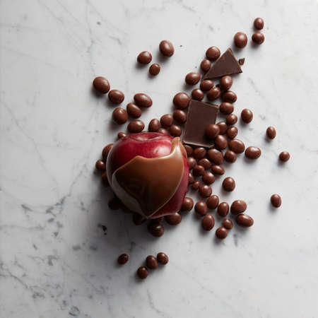 Chocolate on red apple fruit and sweets on white marble backgroundの写真素材