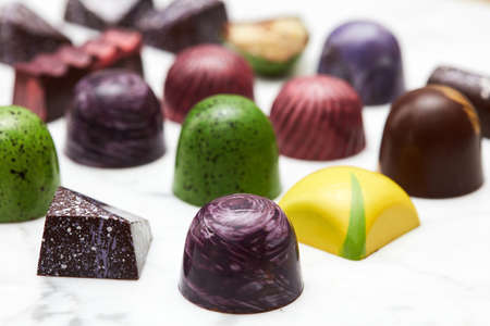 Luxury chocolate candies on a white marble background.
