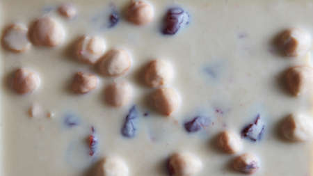 texture of white chocolate with nuts . Food background