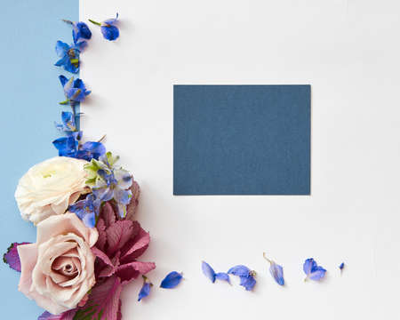Card for greeting or invitation of purple flowers and blue paper on a white background, flat layの写真素材