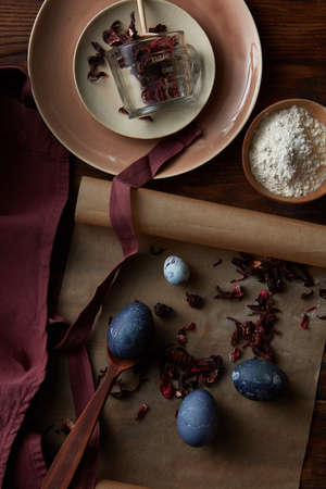 Top view of easter eggs, flour, apron and measuring cupの写真素材