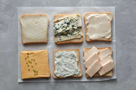 Top view of toasts with different cheeses on baking paperの写真素材