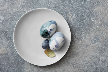 Blue easter eggs on plate over stone background