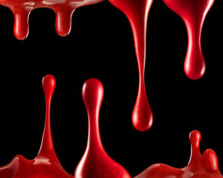 Drops of red paint on a black backgroundの写真素材