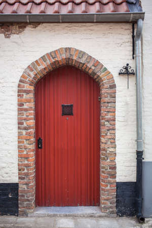 Red door in hause of Bruges, Belgium.の写真素材