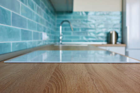View of the kitchen brown countertop with white hobの写真素材