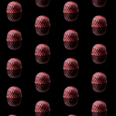 pattern, background of chocolate sweets. tasty candy on a black texture.の写真素材
