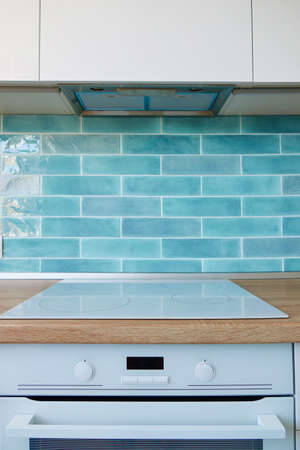 Modern kitchen appliances for white kitchen with brown top and blue tilesの写真素材