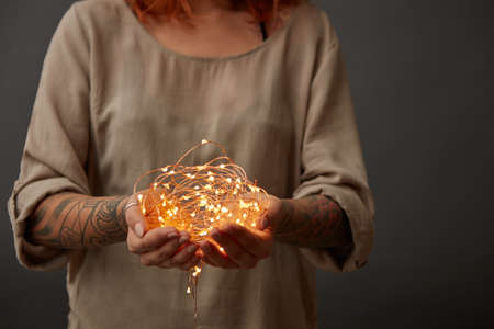 Christmas lights garland in female handsの写真素材