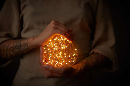 Christmas lights garland in female handsの写真素材