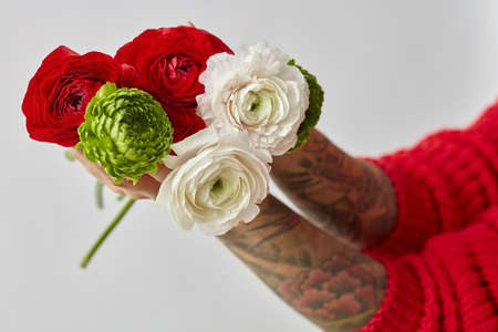 girl with a tattoo on her hands holding a bouquet of flowers