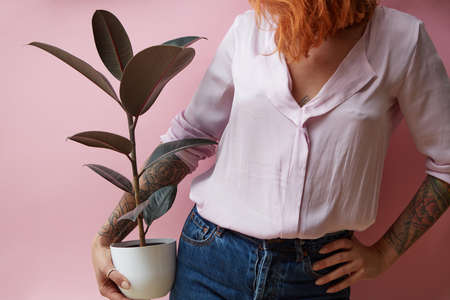girl holding a vase with a ficus