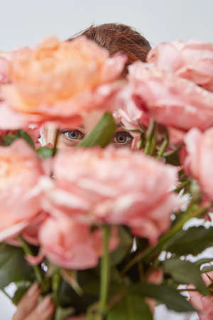 Bouquet of beautiful roses in the hands of a girlの写真素材